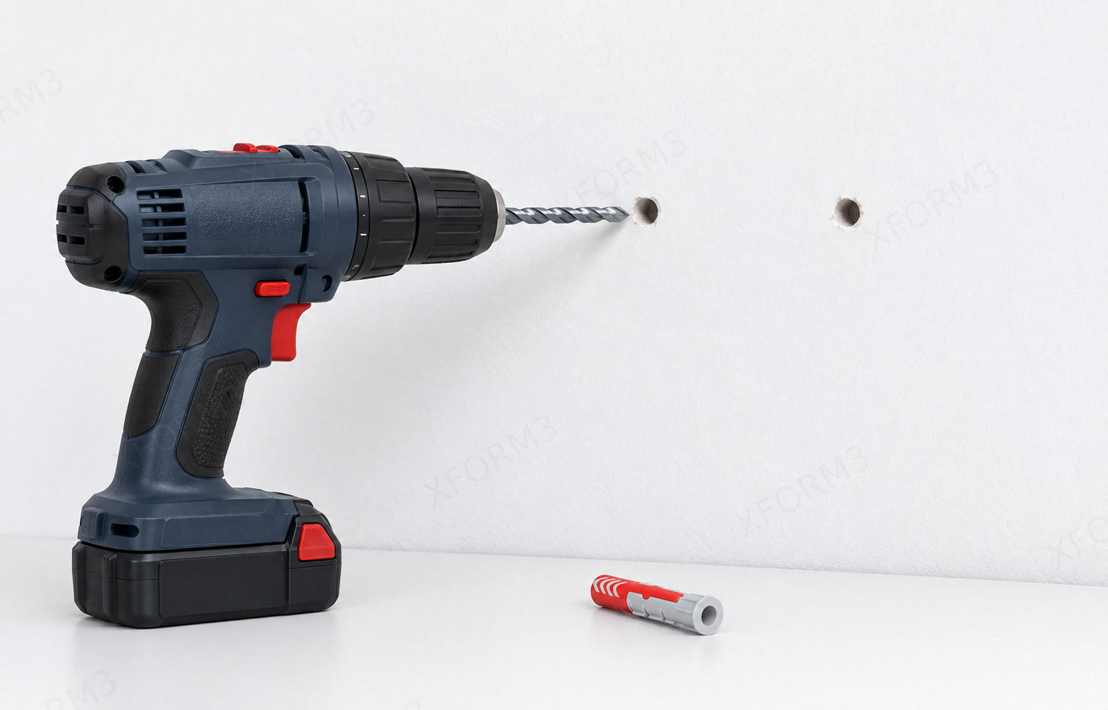 Drill and bit at marked wall holes with a separate red and gray wall anchor nearby