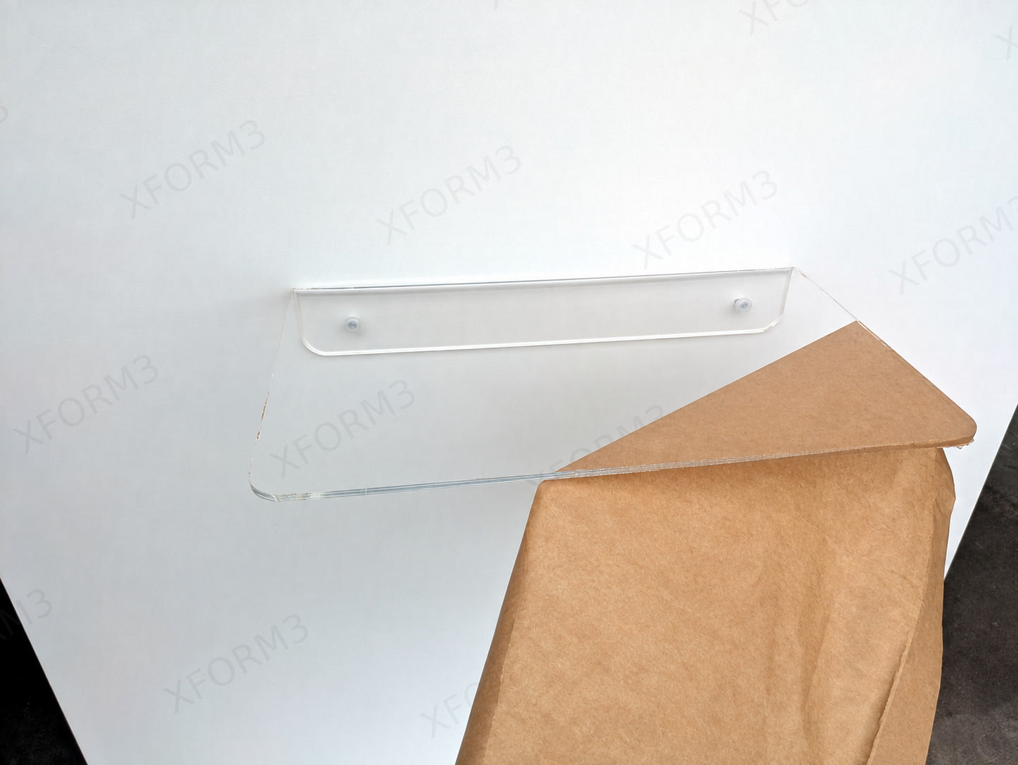 Remaining protective film being lifted from the clear acrylic shelf after mounting